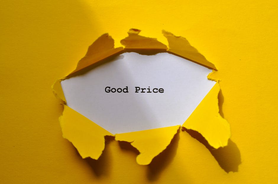 A torn yellow paper with rough, jagged edges reveals a white card inside that displays the typed text 'Good Price'. The torn paper creates a circular opening against a yellow background, emphasizing the message. The lighting is even, highlighting the texture of the torn edges and the contrast between the yellow paper and white card. This image symbolizes value or affordability, fitting within the context of surface cleaning, deep cleaning, or sanitisation services offered by Marylebone Cleaners as part of their domestic cleaning solutions.